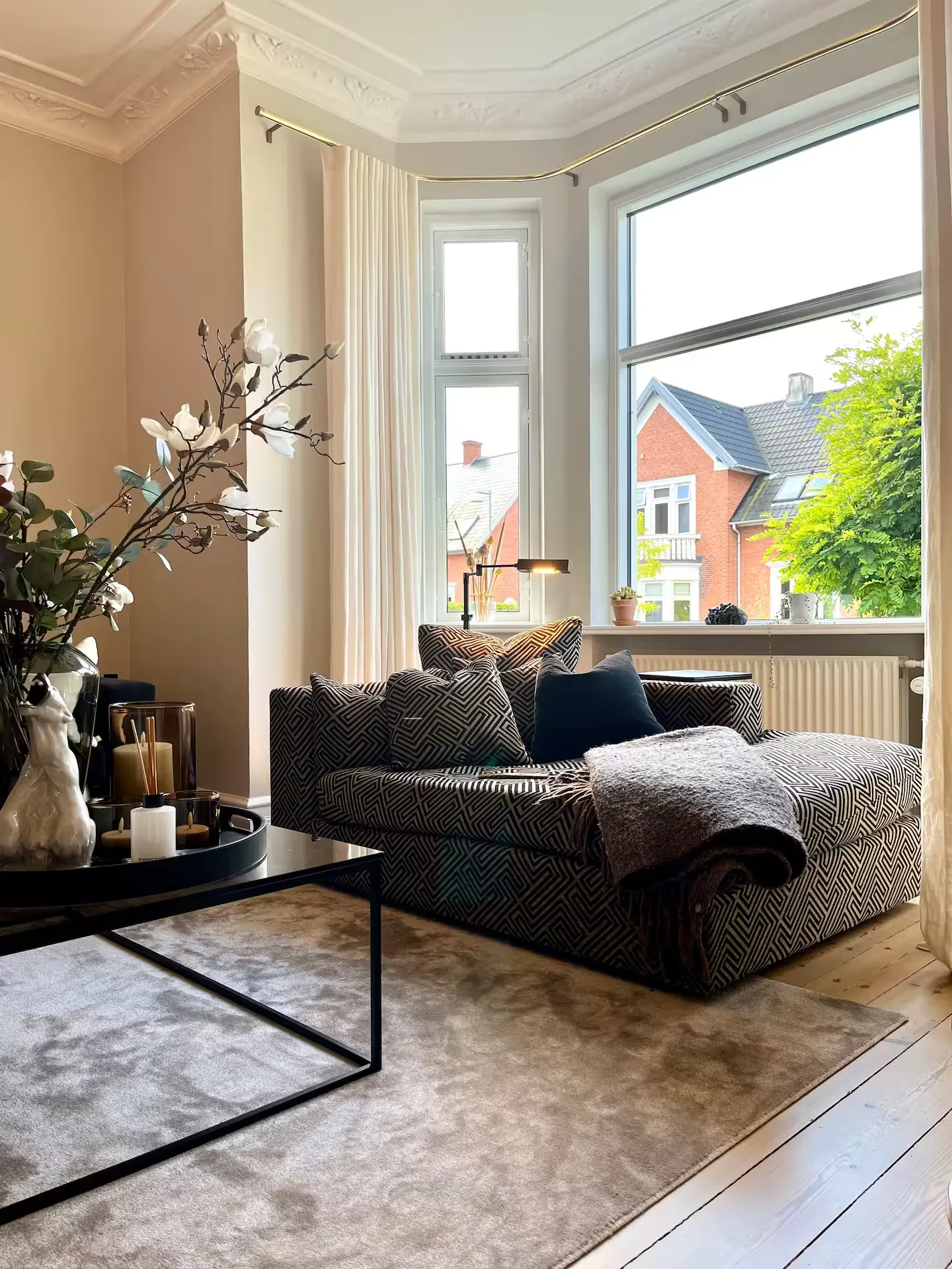 Lys stue med sofa ved vinduet